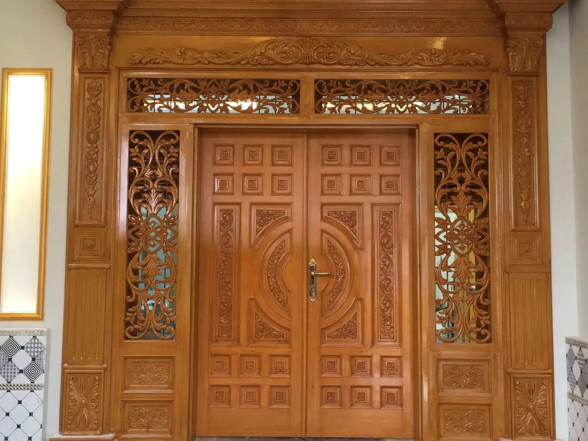 This image showcases a beautifully designed wooden door, featuring intricate carvings and a polished finish that adds a touch of sophistication to any home entrance. Wooden doors are popular for their durability, classic appeal, and versatility in design. From rustic and traditional to modern and minimalist styles, these designs offer a range of options to suit various architectural aesthetics. Whether you’re looking for a grand main entrance door or a sleek interior door, wooden designs provide elegance and warmth that make a statement. Upgrade your home’s entrance with these exquisite wooden door styles, crafted for both beauty and strength